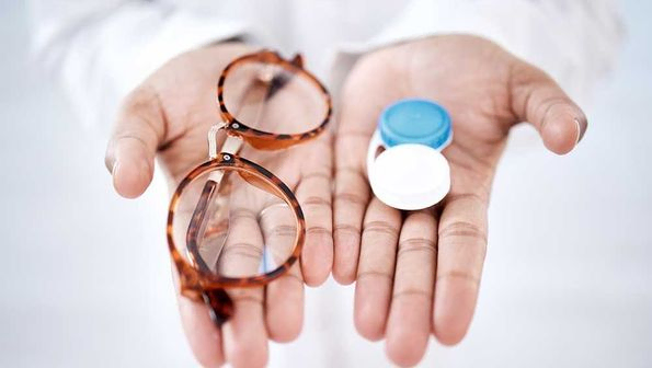 Augenpflege, Wahl mit Brille oder Kontaktlinsen in den Händen, Nahaufnahme und Sehvermögen mit Gesundheitsfürsorge für die Augen.